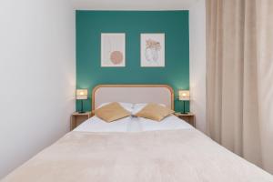 ein Schlafzimmer mit einem weißen Bett mit einer blauen Wand in der Unterkunft Atmospheric Apartment in a Green Area Pet-friendly by Noclegi Renters in Wzgórze Nowotki + 12 Fotos