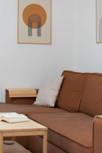 ein braunes Sofa im Wohnzimmer mit einem Tisch in der Unterkunft Atmospheric Apartment in a Green Area Pet-friendly by Noclegi Renters in Wzgórze Nowotki