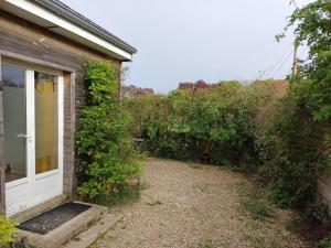 a house with a white door and some bushes at Cosy 2 persons guesthouse with free wifi and parking chez Mostarlić B&B in Bouconville +3 photos