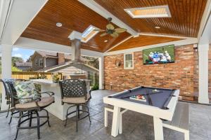 a patio with a ping pong table and a tv at The Raleigh Resort House in Millbrook