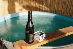 a bottle of wine sitting on a table next to a pool at Matar baYaar מטר ביער in El-Rom +31 photos
