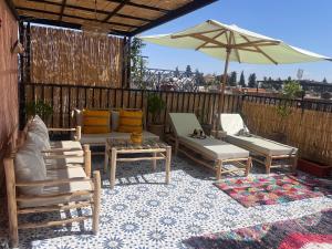 a patio with chairs and a table and an umbrella at Riad Dar Lamia in Marrakech