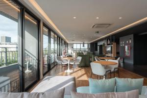 a restaurant with tables and chairs and large windows at GO Carlos Gomes in Auxiliadora