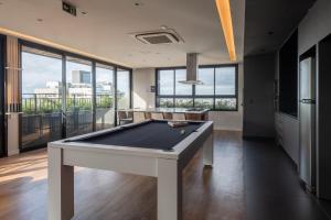 a pool table in a living room with windows at GO Carlos Gomes in Auxiliadora