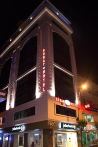 a building with neon signs on the side of it at Elazig Gunay Hotel in Elazığ