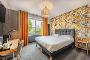 a bedroom with a bed and a large window at The Originals Boutique, Hôtel Spa Le Triton, Roscoff in Roscoff