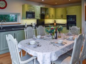 una cucina con tavolo e tovaglia bianca di Chestnut Cottage - Uk48294 a Great Yarmouth
