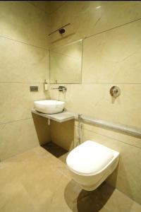 a bathroom with a toilet and a sink at Hotel Manjushree in Pachmarhī