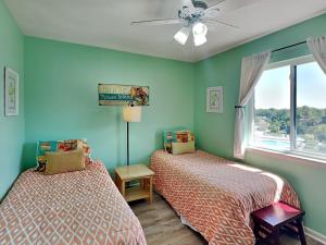 two beds in a room with green walls and a window at Lighthouse Point by Tybee Vacation Rentals in Tybee Island +291 photos