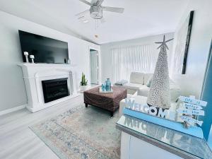 a living room with a fireplace and a christmas tree at Cape Coral Seascape in Cape Coral
