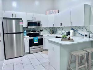 a kitchen with white cabinets and a stainless steel refrigerator at Cape Coral Seascape in Cape Coral