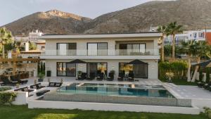 a house with a swimming pool and mountains in the background at Serenity Blue Luxury Villa 7 Bedrooms in Koutouloufari