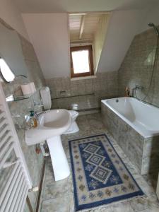 a bathroom with a sink and a tub and a toilet at Pensiunea Mirela in Breaza