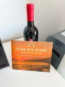 a bottle of wine sitting in a box at Alba sul Mare Apartments in Ali Terme