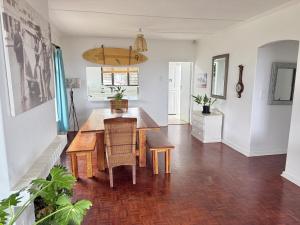 a dining room with a wooden table and chairs at Wazos Beach Villa in Durban