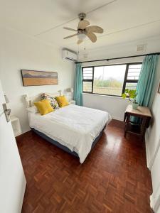 a bedroom with a bed and a ceiling fan at Wazos Beach Villa in Durban