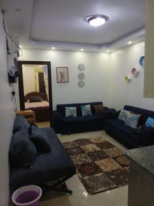 a living room with a blue couch and a mirror at Golf Porto Marina El Alamein studio Aqua 52111 in El Alamein