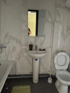 a bathroom with a sink and a toilet and a mirror at Hotel HEADWAY in Kyiv