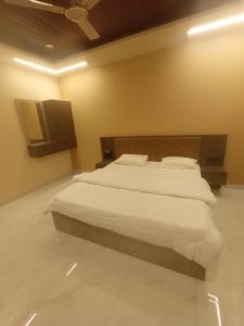 a bedroom with a large bed with white sheets at SringeriRooms in Sringeri