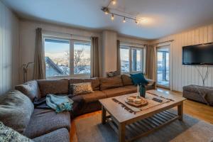 a living room with a couch and a table at Large Ski in-Ski out Apartment for Groups in Hemsedal