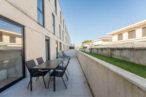 a table and chairs on the balcony of a building at GuestReady - Ultimate Retreat in Apúlia in Apúlia