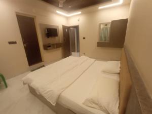 a bedroom with a large white bed in a room at SringeriRooms in Sringeri +2 photos