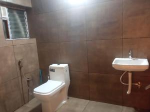 a bathroom with a toilet and a sink at SringeriRooms in Sringeri