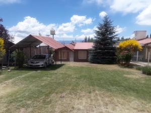 a house with a car parked in the yard at Cabaña Las Candelas in Potrerillos