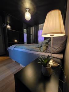 a bedroom with a bed and a table with a lamp at Aurora View Apartment - Free Parking & Walkable City Location in Tromsø