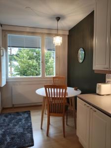 a kitchen with a table and a chair and a window at Kaksio lähellä keskustaa in Iisalmi
