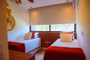a bedroom with two beds and a window at Casa Guaimbê com Rooftop e piscina privativa in São Miguel dos Milagres +36 photos