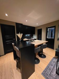 a kitchen with black cabinets and a kitchen island at Aurora View Apartment - Free Parking & Walkable City Location in Tromsø