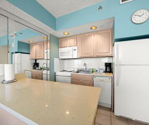 a kitchen with white appliances and a clock on the wall at Barclay Towers in Virginia Beach