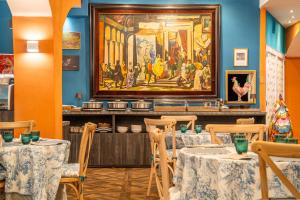 a dining room with tables and a painting on the wall at Hotel Il Guercino in Bologna