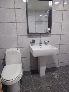 a bathroom with a toilet and a sink and a mirror at Hotelharu in Eumseong