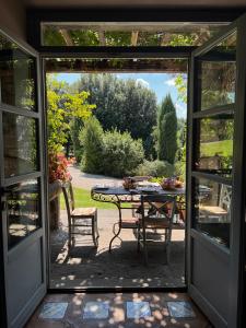 Una puerta abierta a un patio con mesa y sillas. en Villa Rossi Danielli - By TDF, en Viterbo