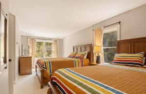 a bedroom with two beds and two windows at 4BR Mountain retreat with Ski Base Bikes & Yard in Bartlett