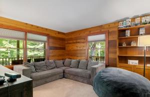a living room with a gray couch and wooden walls at 4BR Mountain retreat with Ski Base Bikes & Yard in Bartlett +26 photos