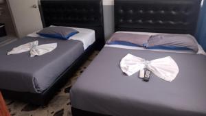 2 camas con lazos de arco en una habitación en Hotel Bogotá Airport, en Bogotá