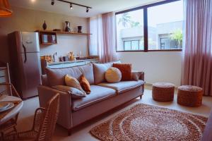 a living room with a couch and a kitchen at Casa Guaimbê com Rooftop e piscina privativa in São Miguel dos Milagres