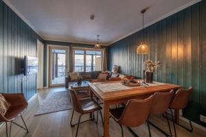 a living room with a wooden table and a couch at Ski in-Ski out with Style and Scenic Views in Hemsedal +18 photos