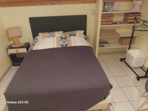 a bedroom with a bed with a black head board at Gite les cèdres in Saint-Priest