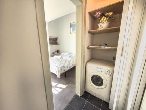 a laundry room with a washing machine and a bed at Viale Volta Authentic Apartment in Florence