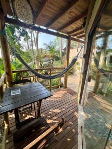 a porch with a bench and a hammock on it at chalés frente à praia in Trindade
