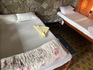 deux lits jumeaux dans une chambre avec un oreiller dans l'établissement The Hotel Orchid & Restaurant, à Kāskī