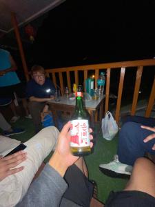 a group of people sitting around a table holding a bottle at Walk in Himalayas in Pelling
