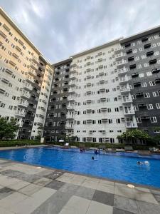 Un gran edificio de apartamentos con una gran piscina. en Paris Theme Near Ayala Feliz Mall 2BR Netflix Internet with Pool Parking Fee, en Manila