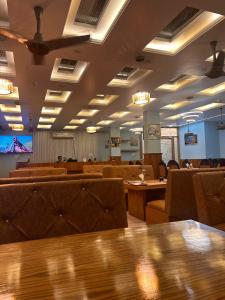 a waiting room with tables and chairs and a tv at The Satluj Vista in Bilāspur