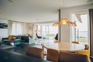 ein Wohnzimmer mit Tisch und Stühlen und einer Couch in der Unterkunft Meervilla Deluxe met Sauna | 8 personen - Boutique Parc Pharshoeke in Heeg