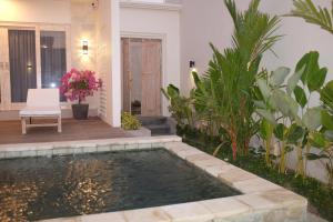 a pool in a backyard with a chair and a house at the gosana in Amed